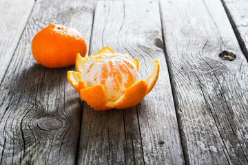 Wall Mural - peeled and whole tangerines on old wood table