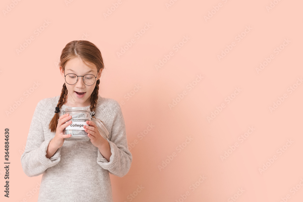 Surprised girl with savings for education on color background