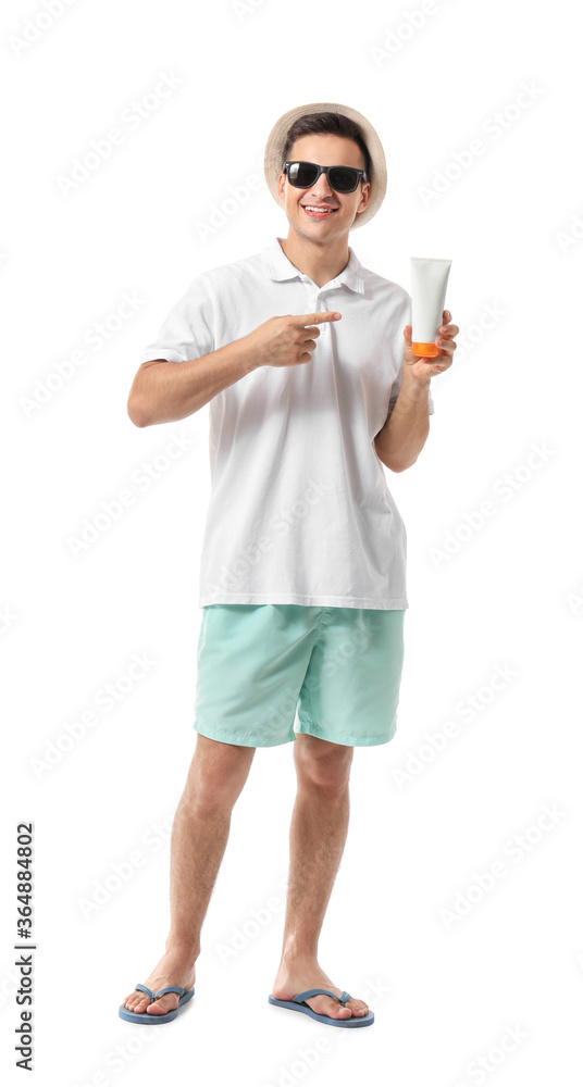 Happy young man with sun protection cream on white background