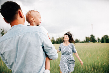 Poster - A happy family walks with a child in nature