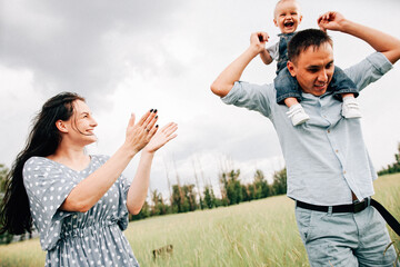 Wall Mural - A happy family walks with a child in nature