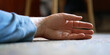 © Bonsales - ill man in blue pullover hand lies on side on floor closeup