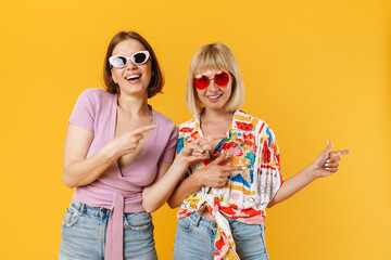 Poster - Portrait of two cheerful lovely girlfriends standing