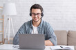 © Prostock-studio - Customer service online at home. Guy with glasses and headset, looking at laptop, sitting at table