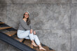 © Drobot Dean - Photo of happy gray-haired asian woman smiling while sitting on stair