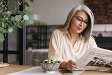 Woman Indoors At Home Reading Newspaper