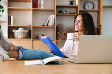 Sticker - Image of smiling businesswoman drinking coffee and reading documents