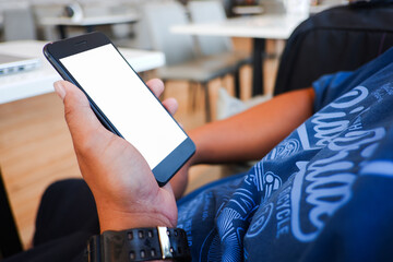 Cropped shot view of man’s Hands hold the smartphone with blank copy space screen for your information content or text message on the gray granite at the modern place.