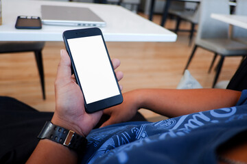 Cropped shot view of man’s Hands hold the smartphone with blank copy space screen for your information content or text message on the gray granite at the modern place.