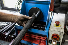 Worker, Cutting Hydraulic Hoses In A Metal Workshop