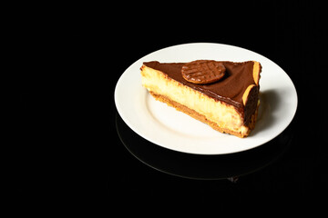 Wall Mural - slice of Dutch chocolate covered pie on white plate on black reflective background