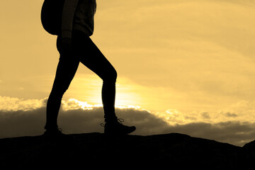 Wall Mural - hiker's legs on the rocky trail at summer sunset. travel and adventure concept.