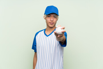 Wall Mural - Young asian man playing baseball over isolated green background