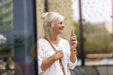 Canvas Print - Portrait of senior woman using smartphone in the city
