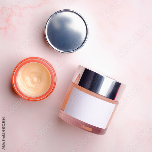 Set of cosmetic cream jars on pink background. Flat lay, top view. Beauty products packaging design, container mockup.