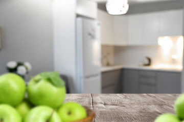 Poster - Wooden table with apples in modern kitchen interior