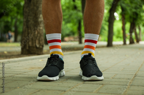 Man in black sneakers and LGBT socks standing outdoor