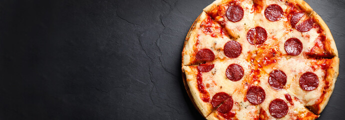 Top view of hot delicious pizza on dark table, space for text. Banner design