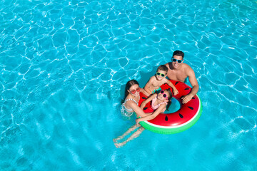 Wall Mural - Happy family with inflatable ring in swimming pool, space for text. Summer vacation