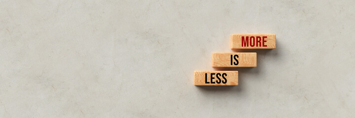 Wall Mural - cubes with message LESS IS MORE on concrete background
