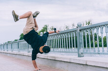 B-boy Break Dancer Stands On One Arm With An Action Camera.