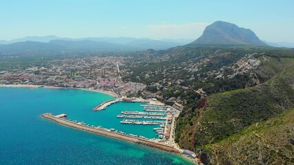 Poster - Aerial drone point of view coastal town of Javea with green mountains, turquoise bay Mediterranean Sea moored vessels in harbour, comarca of Marina Alta in province of Alicante, Valencia, Spain