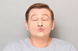 © Andrei Korzhyts - Portrait of funny mature man pouting his lips and blowing kiss