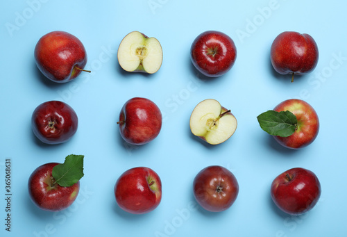 Cuadros en Lienzo Tasty red apples on light blue background, flat lay