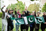 Fototapeta  - Group of pakistani man wearing traditional clothes salwar kameez or kurta with Pakistan flags.