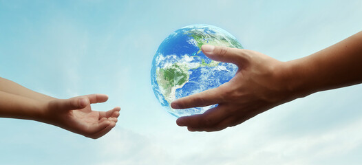 Wall Mural - concept - hands of adult giving planet earth to child - elements of this image furnished by NASA