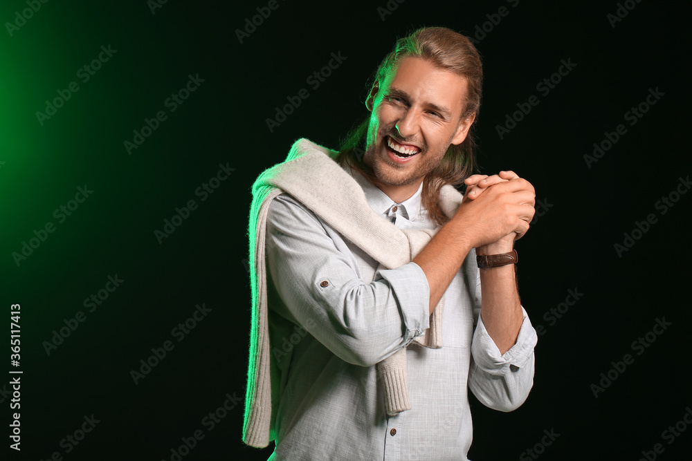 Handsome man with stylish hairdo on dark background