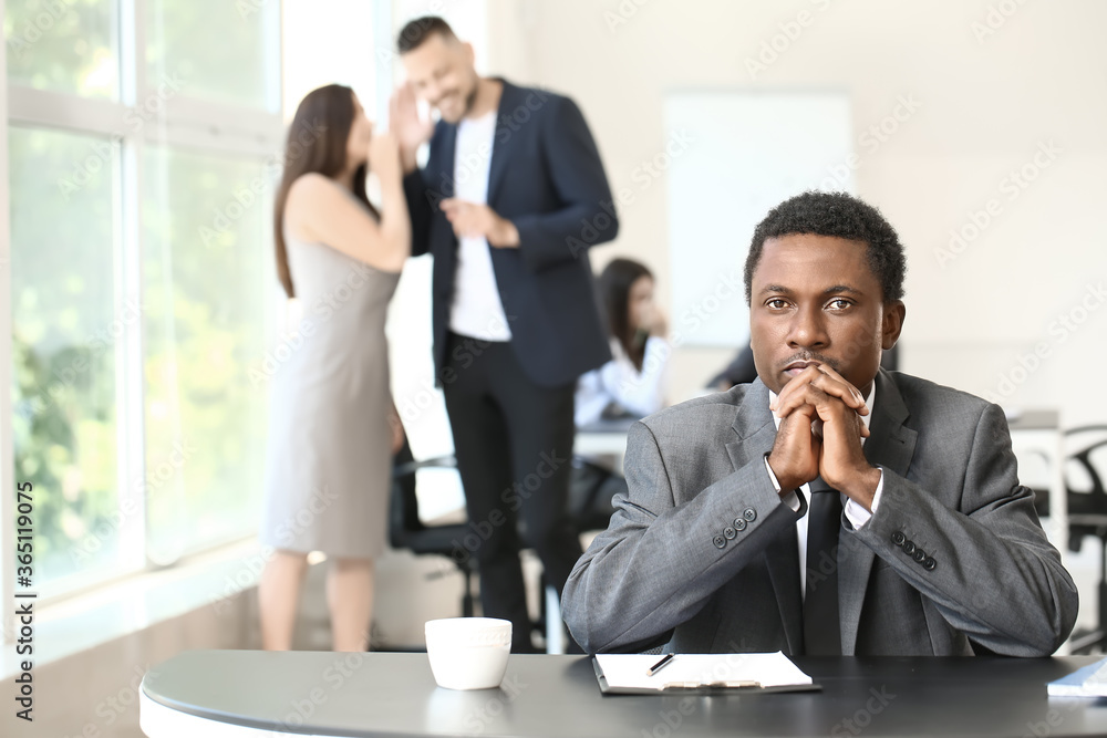 Lonely African-American businessman in office. Stop racism