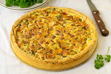 Wall Mural - Quiche with chanterelles, herbs and cheese on a white background