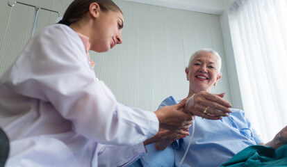 Positive minded doctor taking care of elderly woman at hospital, women doctor and elderly patient