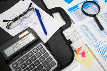 business office desk closeup - financial reports, analysis and accounting, set of documents, tables and graphs, various items for bookkeeping, calculator