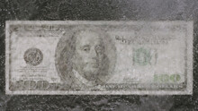 Ice melts on US dollar bill on table - Top view