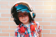 Portrait Of Boy With Russian Pilot's Helmet On Brick Wall