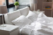 coziness and interior concept - cozy bedroom with white linen on bed