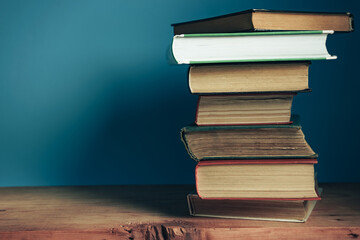 Poster - Beautiful open books on a old red wooden table and blue wall background.