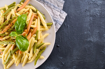 Wall Mural - Traditional pasta trofie south of Italy with pesto and basil. Homemade meal for lunch. Healthy, tasty, meat-free food. Italian Cuisine. High quality photo. Copy space. Layout, top view. Close-Up 