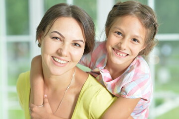 Canvas Print - Portrait of a charming little girl hugging with mom at home