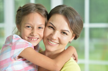 Poster - Portrait of a charming little girl hugging with mom at home