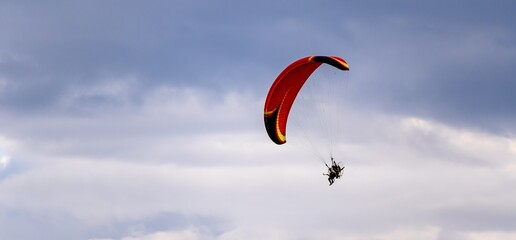 Poster - Red dome of a motor paraglider against a blue evening summer sky.