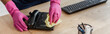 Panoramic crop of african american cleaner in rubber gloves cleaning telephone wit rag in office