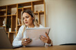 © bnenin - Portrait of a businesswoman preparing for online meeting.
