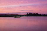 Fototapeta Niebo - Beautiful pink vibrant sunset on a forest lake