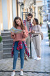 © zinkevych - Girl looking with map, boyfriend with girlfriend talking behind