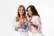 © Drobot Dean - Image of charming two women using mobile phone and holding credit card