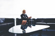 © BullRun - Trendy woman reading text message from her boyfriend on mobile phone during work break in office interior, young glamour female chatting on cell telephone while waiting in studio for photo shooting