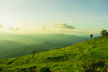 Wall Mural - sunset and mountains interspersed with green grass